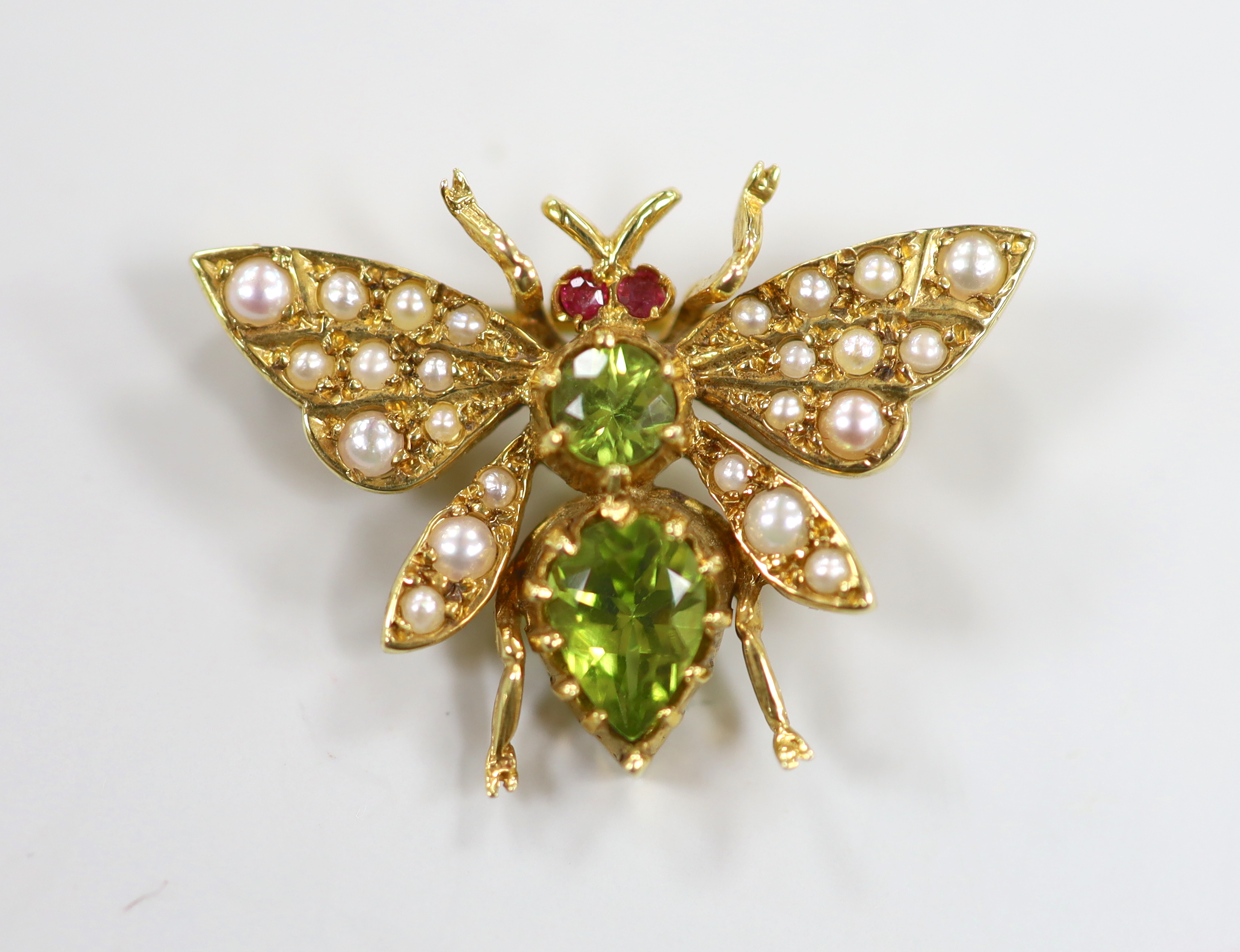 A modern 9ct gold peridot, seed pearl and ruby set novelty bug brooch, width 25mm, gross weight 3.6 grams.